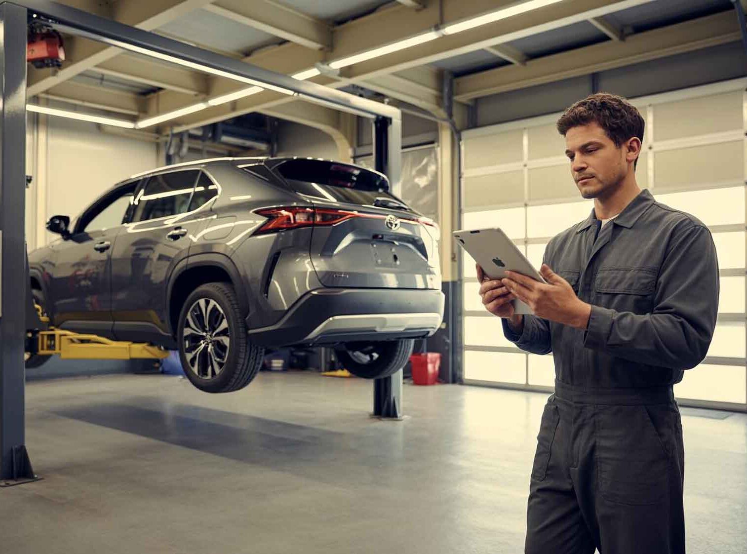 ADAS Calibration Services – Tech standing behind toyota on lift – action colors ADAS Calibration Services - Tech standing behind toyota on lift - action colors